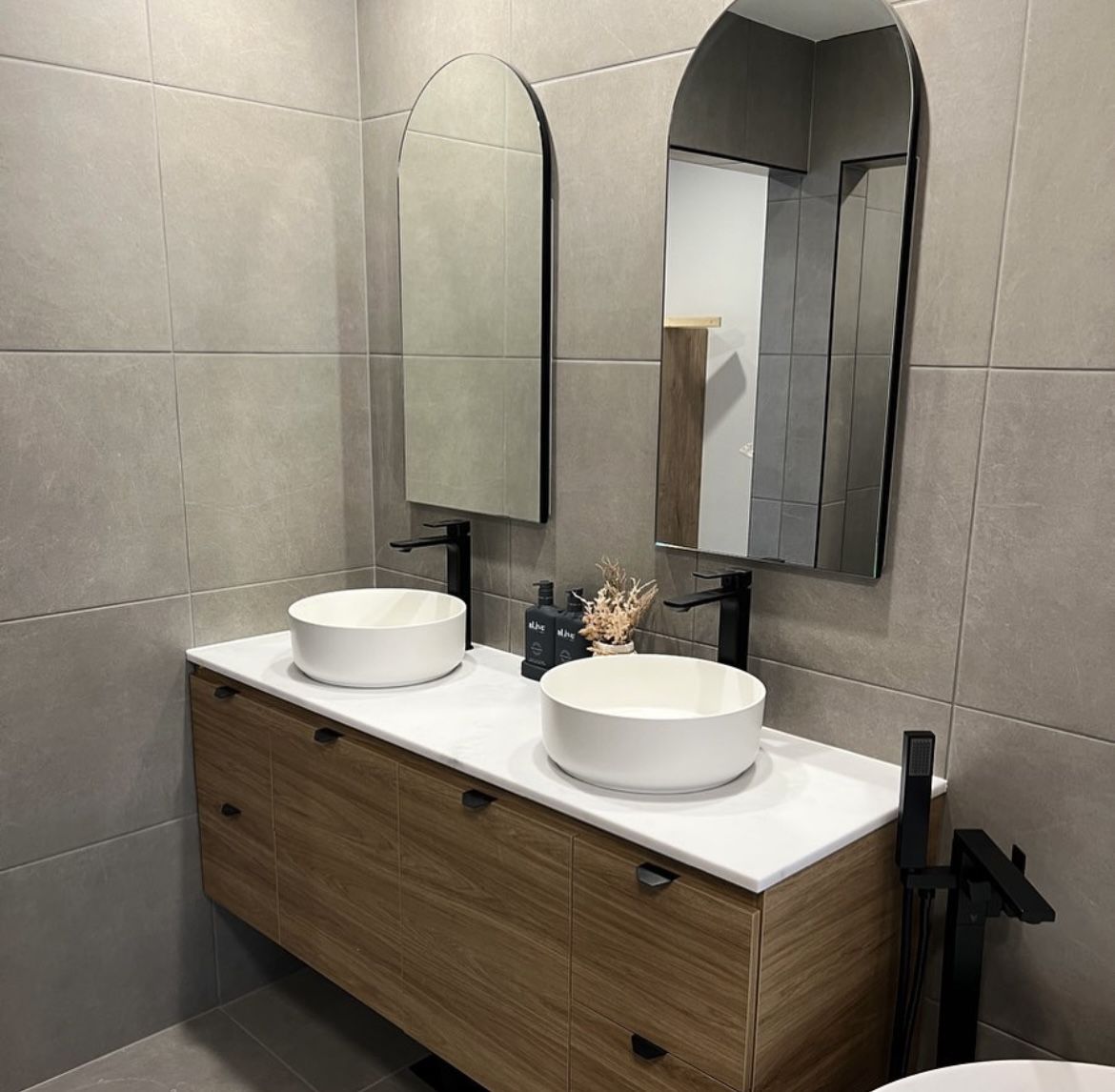 Bathroom renovation with timber floating vanity, twin vessel basins and arched mirrors — Davidson Plumbing and Gas